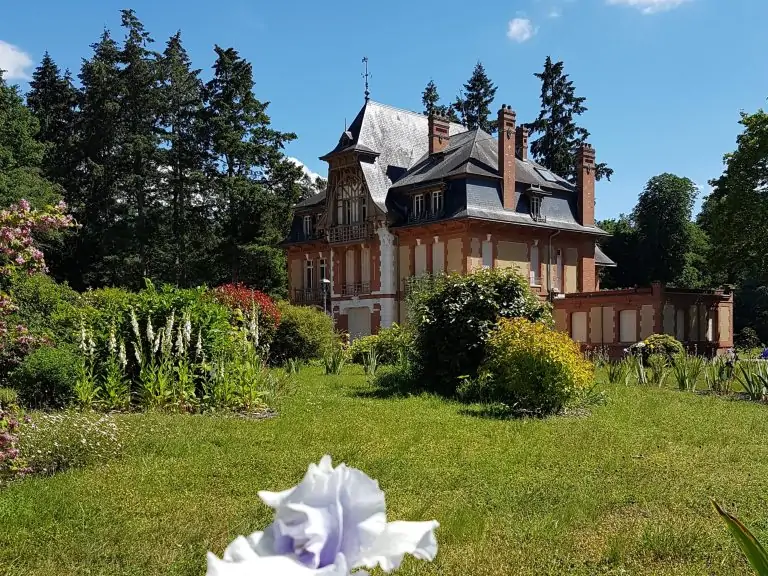 Le château de Morchêne vu du jardin, entouré de massifs d'iris en fleurs